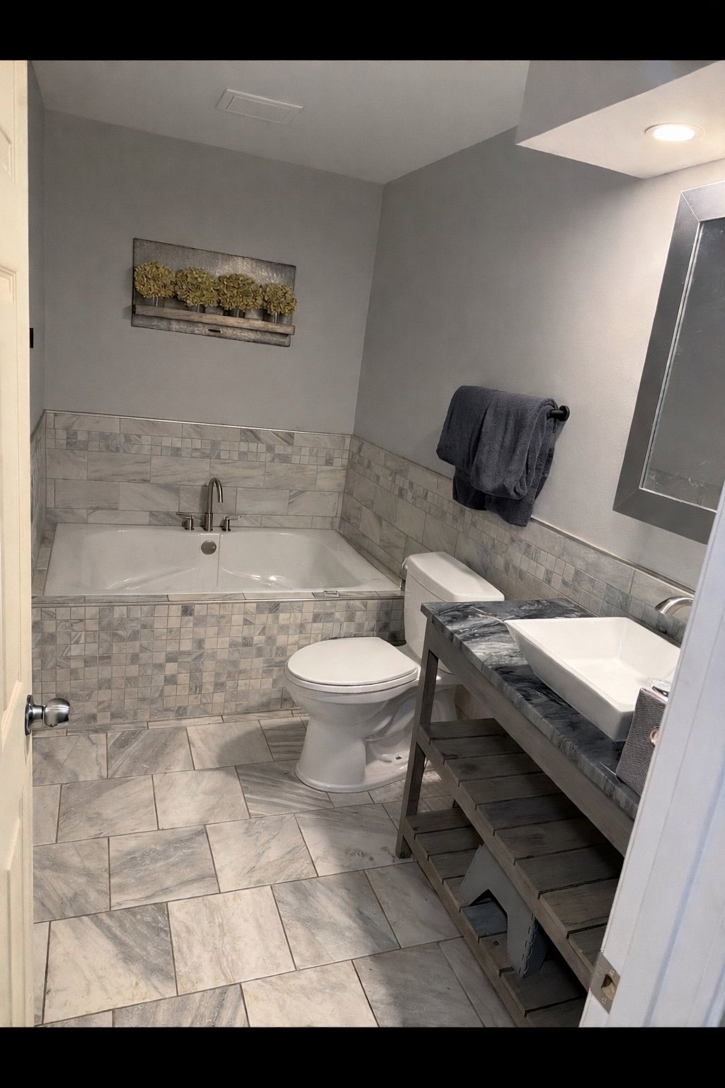Finished full bathroom with tub, vanity, tile and flooring